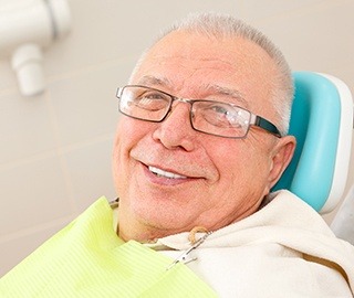 Smiling senior man in dental chair after full mouth reconstruction
