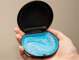 Closeup of Invisalign aligners in black and blue case