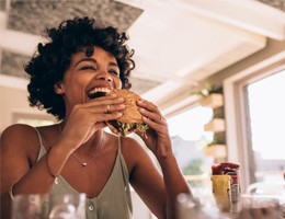 Woman smiling while eating at restaurant