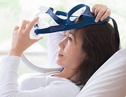Woman placing her CPAP mask