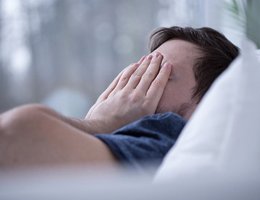 Man tired in bed needs sleep apnea therapy