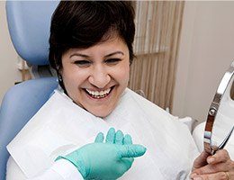 Woman smiling in dental chair after T M J therapy