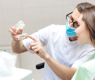 dentist showing a patient how dental implants work