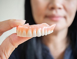 Woman holding dentures