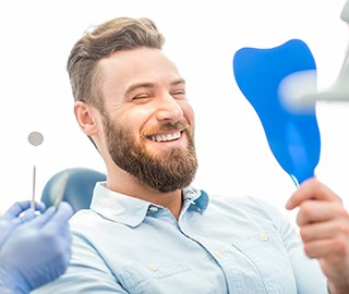 Man smiling at his dental implants in Ann Arbor