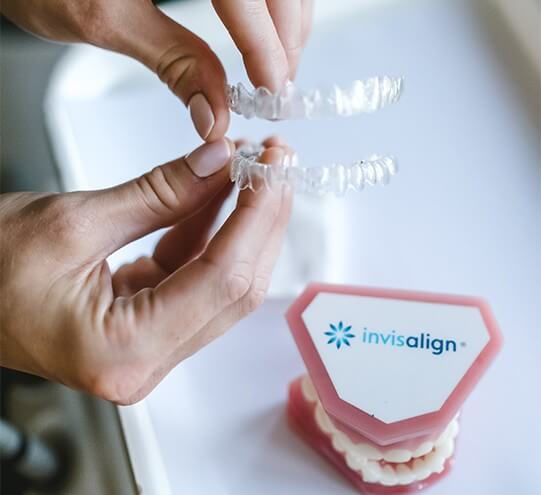 Person holding Invisalign clear aligners