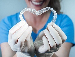 Dentist holding Invisalign aligners in a heart shape