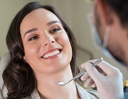 Smilig woman in dental chair for periodontal therapy