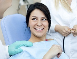 Smiling woman in dental chair after root canal therapy