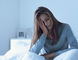 Woman tired in bed needs sleep apnea therapy