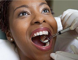 Woman receiving dental exam using the TENS system