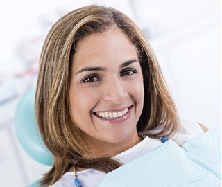 Smiling woman in dental chair for tooth colored filling treatment