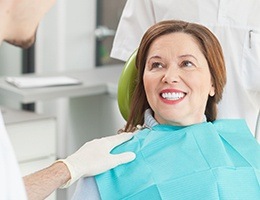 Smiling woman in dental chair after tooth colored filling treatment