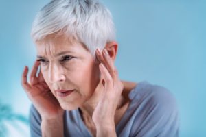 Frowning older woman with tinnitus